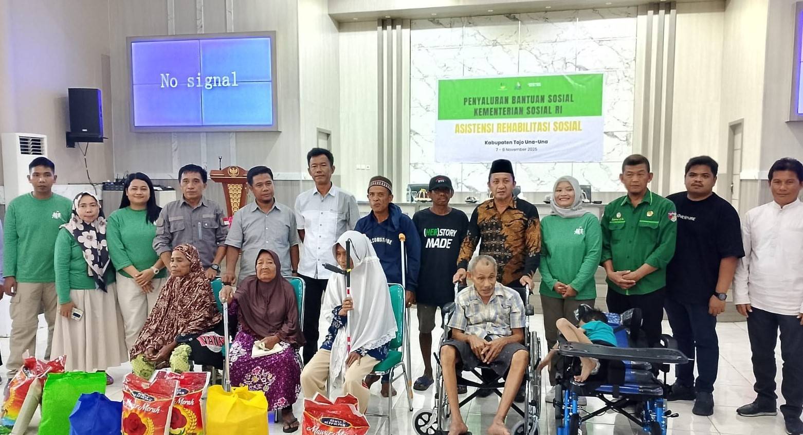 Perwakilan Kemensos RI dan Pemkab Tojo Una-Una berfoto bersama penerima manfaat usai penyaluran bantuan sosial program ATENSI